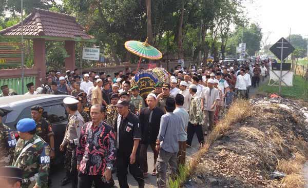 Ribuan massa mengantar kepergian KH Abdy Manaf ke tempat pemakaman, kemarin. foto: mustain/BANGSAONLINE
