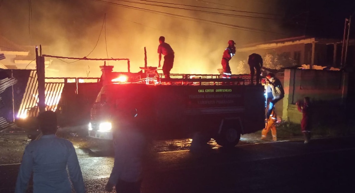 Mobil damkar beserta petugas yang tiba di TKP kebakaran saat melakukan pemadaman api