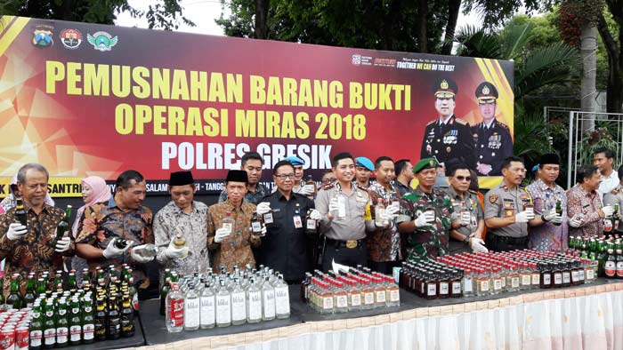 Kapolres Gresik AKBP Wahyu Sri Bintoro bersam jajaran Forkopimda dan tomas saat pemusnahan BB miras. foto: SYUHUD A/BANGSAONLINE