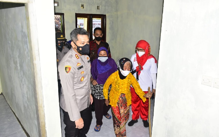 Nenek Tukinem diantar  Kapolres memasuki rumahnya yang baru dan kokoh setelah sebelumnya roboh terkena gempa Malang.