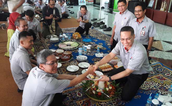 Direktur Utama Semen Indonesia, Rizkan Chandra menyerahkan potongan tumpeng kepada karyawan saat syukuran usia PT Semen Gresik ke-59 tahun. foto: SYUHUD/ BANGSAONLINE