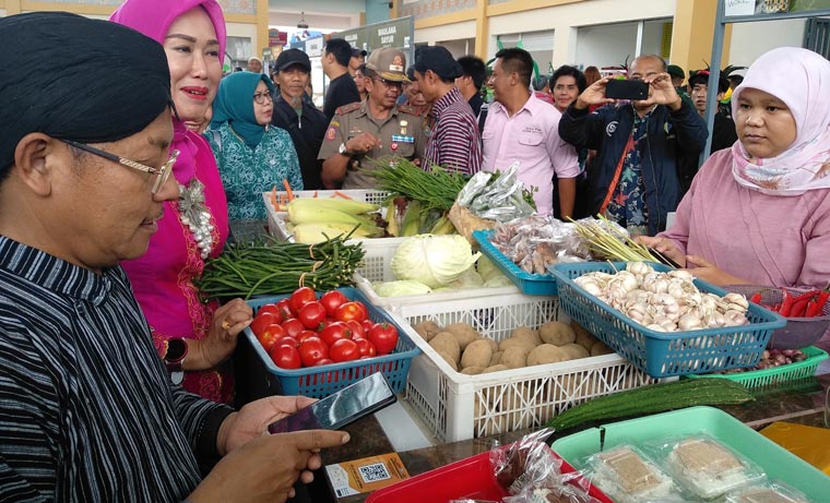 Wali Kota Malang Sutiaji didampingi Ketua TP PKK Widayati Sutiaji saat mempraktikan pembayaran nontunai lewat aplikasi di pasar pintar Joyo Agung Market, Kamis (20/02). foto: IWAN IRAWAN/ BANGSAONLINE