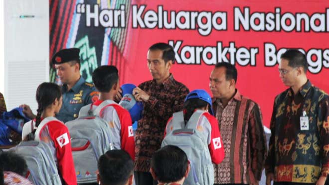 Presiden RI, Joko Widodo menyematkan atribut kepada peserta Program Siswa Mengenal Nusantara didampingi Direktur Utama Semen Indonesia, Rizkan Chandra (Paling kanan) di Kupang. foto: SYUHUD/ BANGSAONLINE