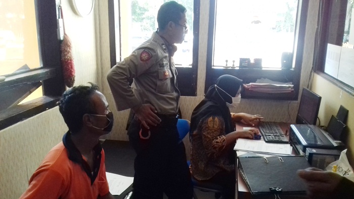 Korban sedang melaporkan kehilangan sepeda motornya ke polisi.