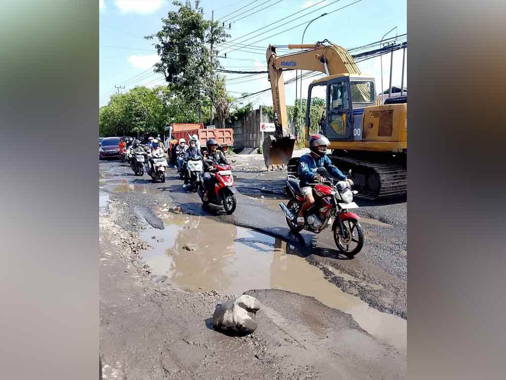 Alat berat saat diterjunkan untuk perbaikan saluran air di bahu Jalan Mayjend Sungkono, Kecamatan Kebomas yang rusak berat. (Ist)