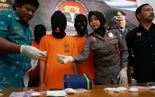 Tersangka pengedar pil koplo beserta barang bukti. foto: rony suhartomo/BANGSAONLINE