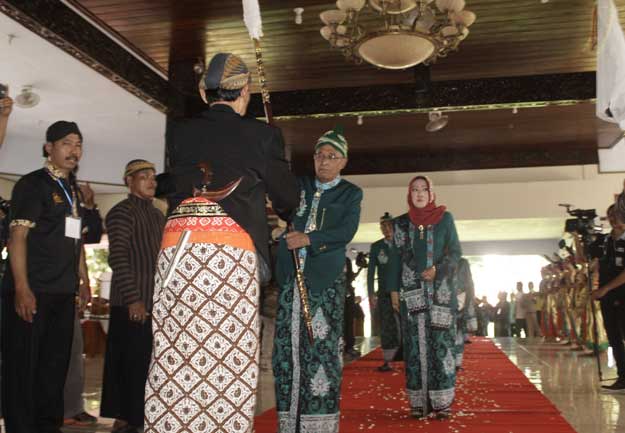 Plt Bupati Nganjuk KH Abdul Wachid Badrus menyerahkan pusaka tombak yang selalu mengiringi setiap prosesi boyongan. foto: Bambang/ BANGSAONLINE