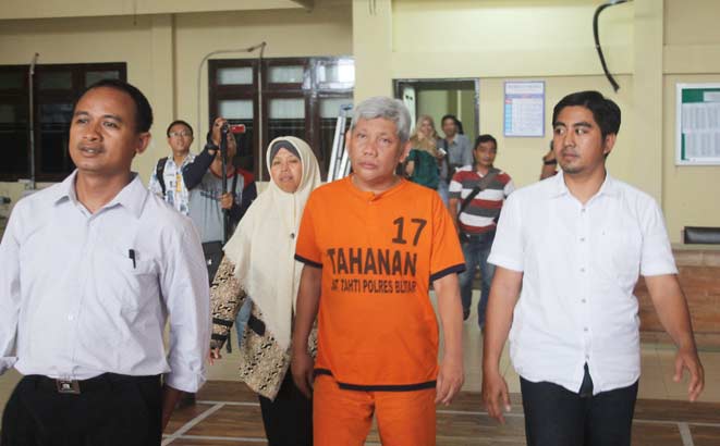Tersangka saat akan diperiksa di Mapolres Blitar.