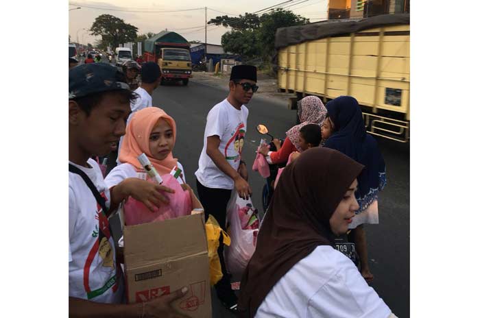 Ketua BMI Gresik Chessy Bima saat membagikan takjil. foto: SYUHUD/ BANGSAONLINE