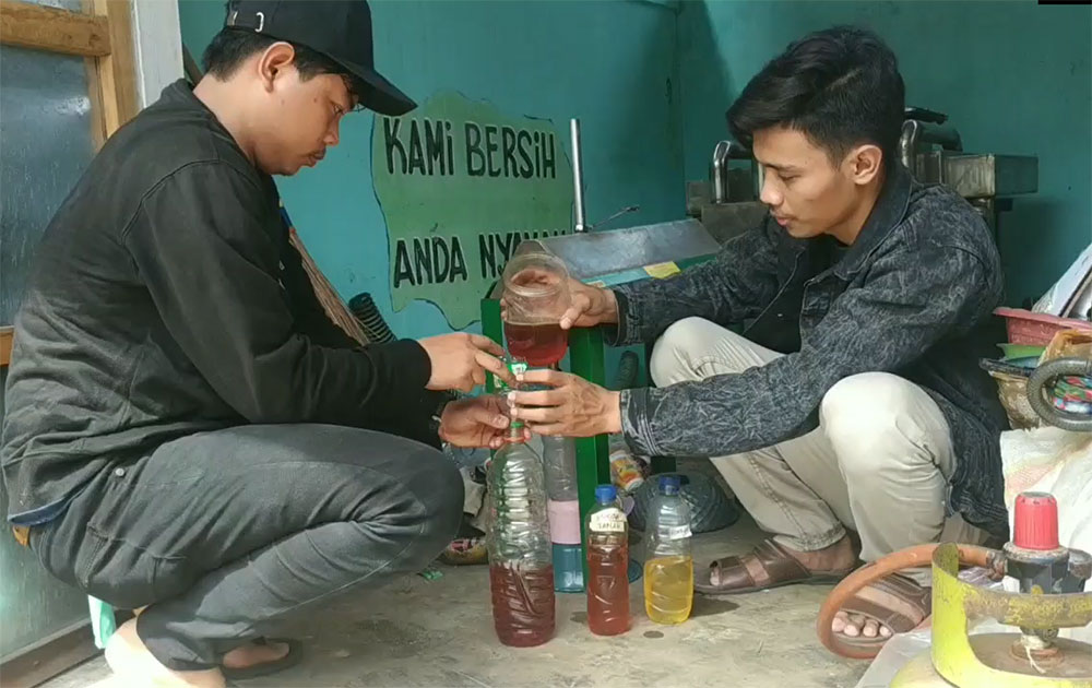 Pemuda Karang Taruna Kelurahan Tambaan saat menunjukkan BBM yang dihasilkan dari pengolahan sampah plastik.