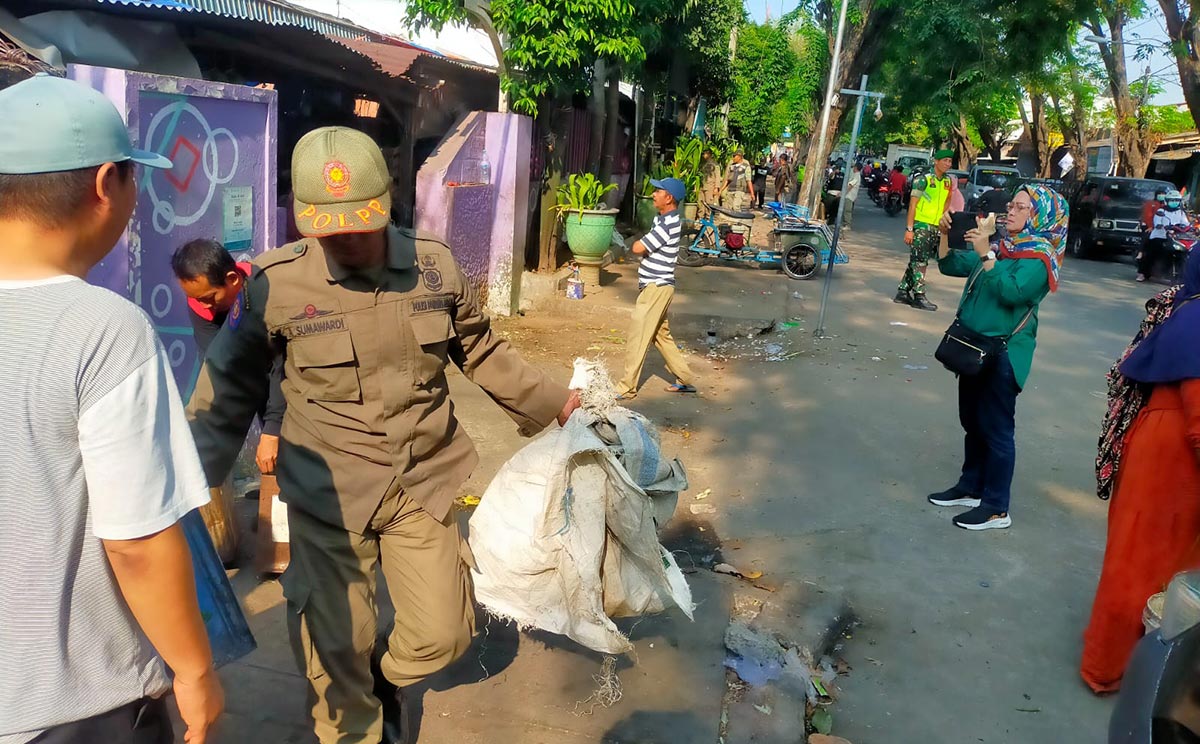 Petugas saat menyita barang dagangan yang ditinggalkan pemiliknya.