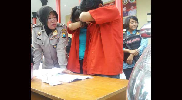 Pasutri yang melakukan penipuan didampingi Kasubag Humas Polrestabes. ft: ekoyono/ BANGSAONLINE