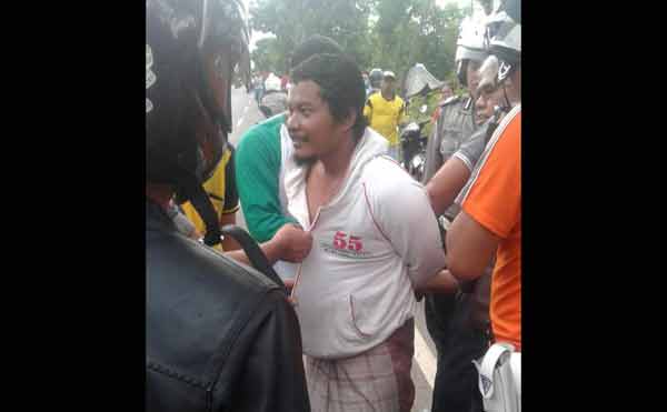 Salah seorang pria terduga teroris diamankan warga dan polisi saat penyergapan di ladang jagung Desa Suwalan, Kecamatan Jenu, Kabupaten Tuban. foto: SUWANDI/ BANGSAONLINE