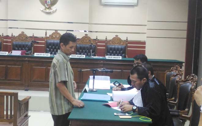Mantan Dirut PDAM Sidoarjo, Sugeng Mujiadi, saat berkonsultasi dengan kuasa hukum yang baru ditunjuk menjelang persidangan. foto: NANANG/ BANGSAONLINE