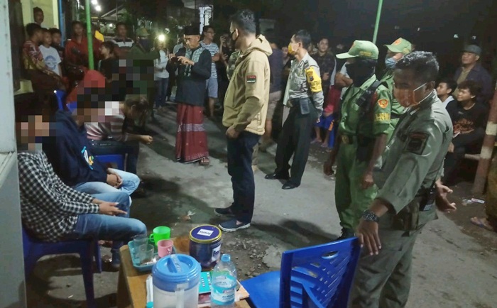 Warga dan petugas saat mengamankan 2 pasangan mesum bukan suami istri yang sedang indehoi di tempat kos. foto: ist