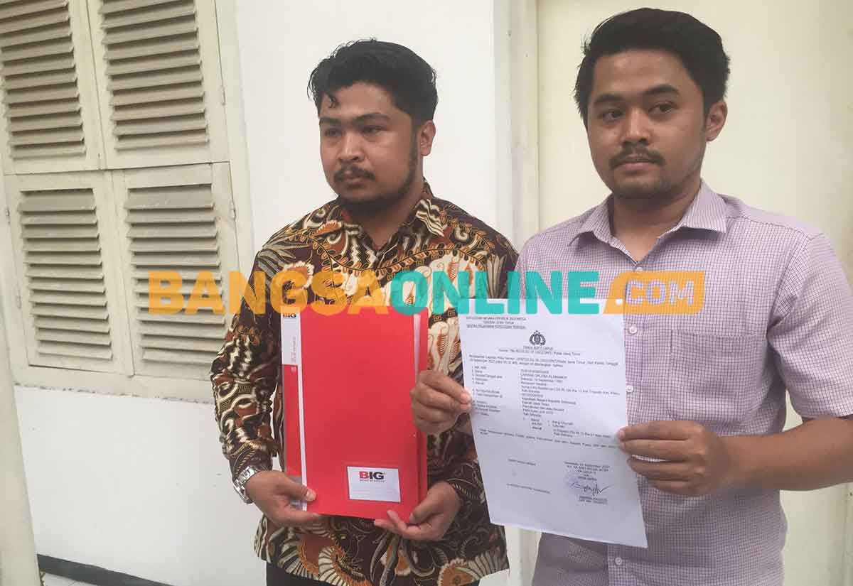 Suami korban pelecehan saat menunjukkan bukti laporan di Polda Jatim. Foto: RUSMIYANTO/BANGSAONLINE