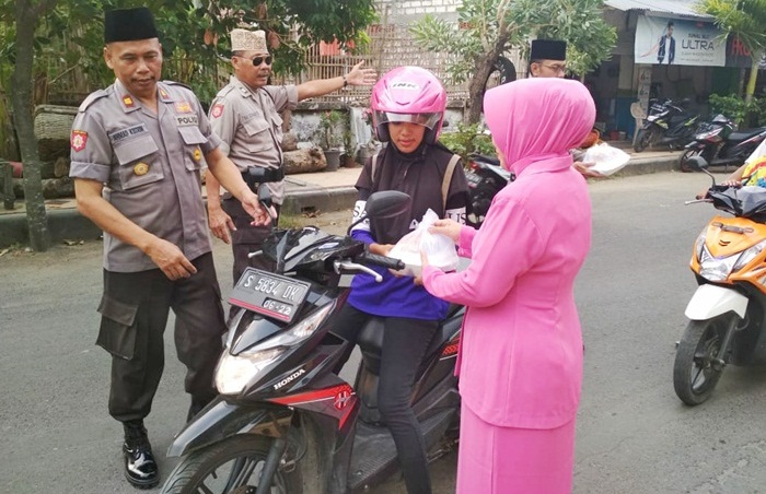 Petugas Polsek Senori bersama istri saat berbagi takjil kepada pengguna jalan. 