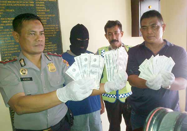 Kapolsek Mulyorejo Kompol Kuncoro menujukkan upal palsu yang ditemukan di tangan tersangka. (foto: rusmiyanto/BANGSAONLINE)
