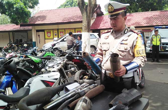 Petugas menunjukkan knalpot brong yang berhasil disita.