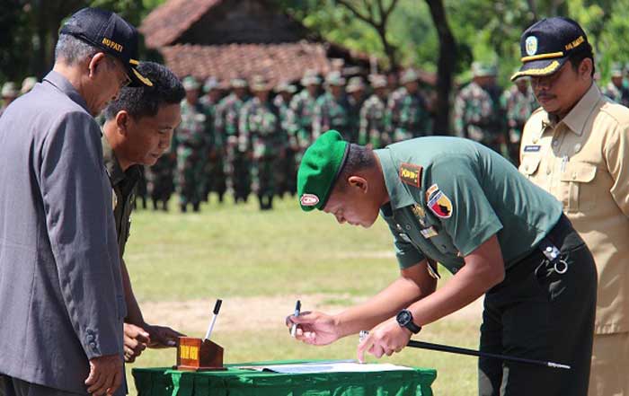 Plt Bupati Nganjuk didampingi Dandim 0810, Ketua DPRD saat membuka TMMD dengan pemukulan kentongan. Foto: bambang /BANGSAONLINE