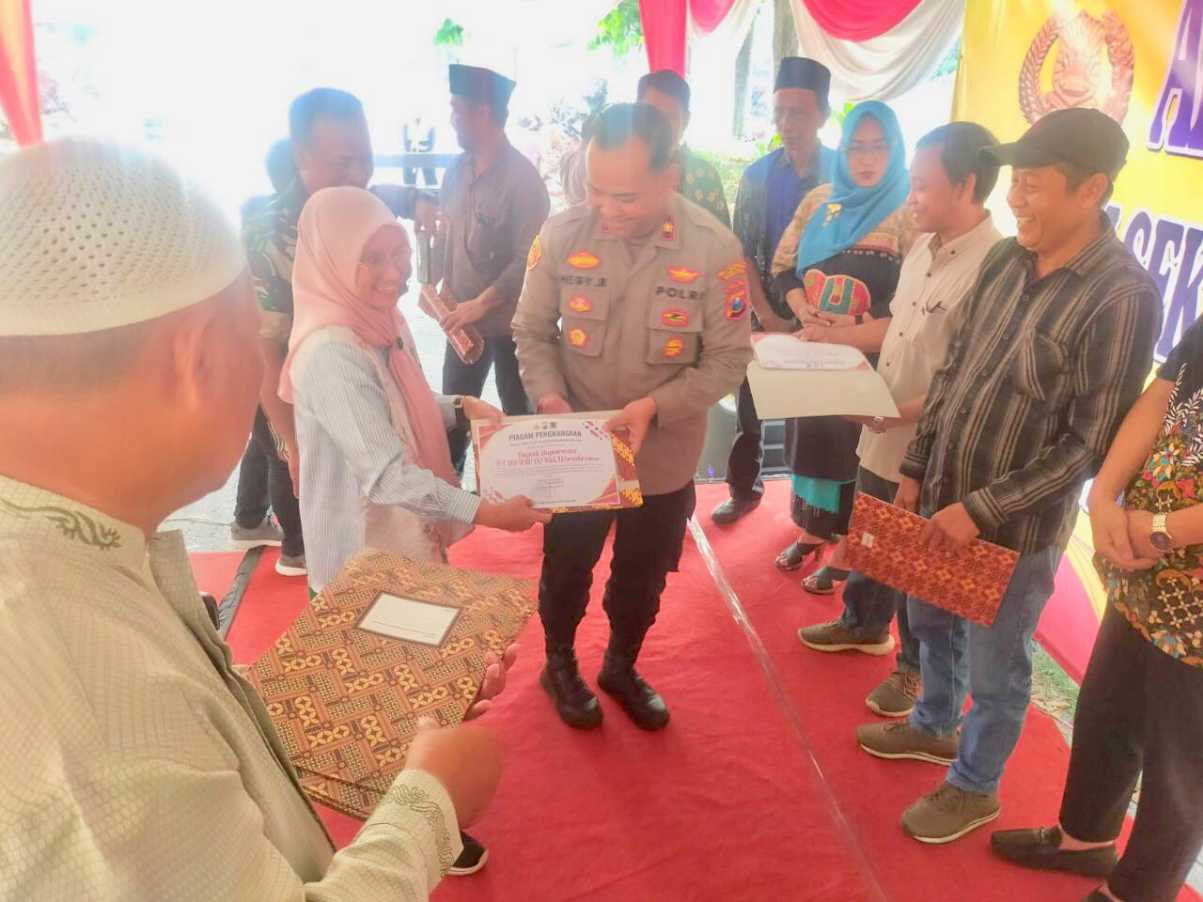 Kapolsek Wonokromo saat menyerahkan penghargaan kepada warga dan ormas 