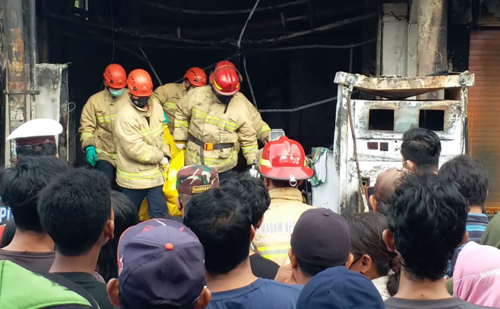 Petugas damkar saat mengevakuasi korban meninggal.