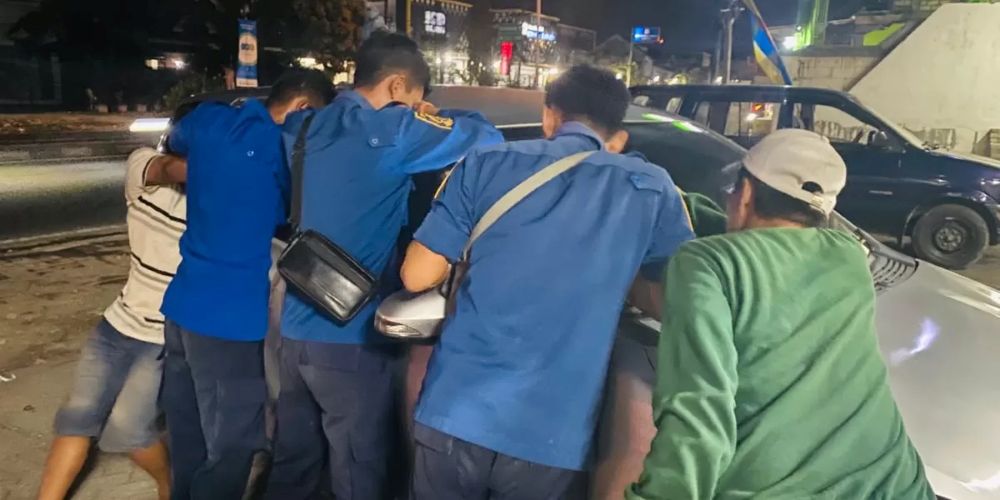 Anggota Damkar Lamongan saat mencoba membuka pintu mobil milik warga Surabaya yang terkunci dari dalam