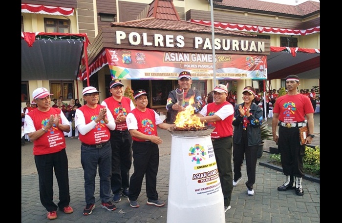 Kapolres Pasuruan saat menyalakan Api Obor pembuka Asian Games Mini di halaman Mapolres Pasuruan. Foto: ANDY F/BANGSAONLINE