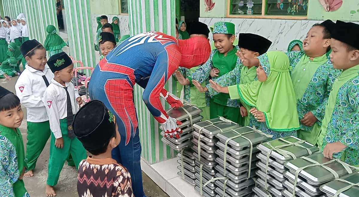 Spiderman saat membagikan program MBG atau makan bergizi gratis di MI Bustanul Ulum, Jombang.