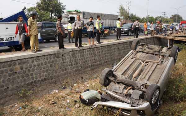 BAWA MAUT: Mobil Ertiga yang terbalik di sungai usai tabrak pengendara. foto: rony suhartomo/BANGSAONLINE