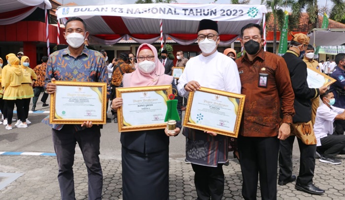 Wabup Aminatun Habibah bersama Kadisnaker Budi Rahardjo dan perwakilan perusahaan sedang menunjukkan penghargaan K3 dari Gubernur Jatim. foto: SYUHUD/ BANGSAONLINE