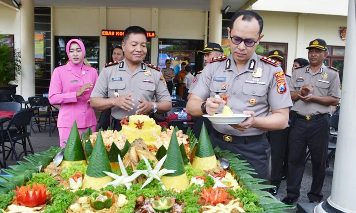AKRAB: Kapolres Batu AKBP Harviadhi Agung Prathama menyuapi salah seorang personel Polres Batu yang tengah merayakan ulang tahunnya, Senin (2/3).