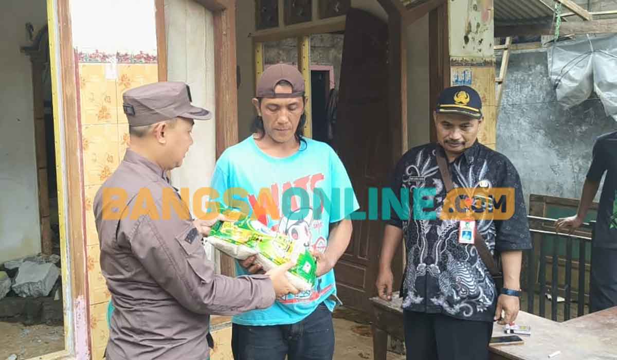 Kasi Intelijen Kejari Kabupaten Kediri, Iwan Nuzuardhi, saat menyerahkan bantuan kepada Janu, salah satu korban tanah longsor. Foto: MUJI HARJITA/BANGSAONLINE