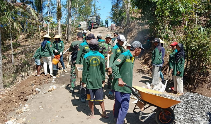 Satgas TMMD ke-106 Kodim Malang bahu membahu bersama warga menggarap pengecoran jalan Desa Kedungsalam.