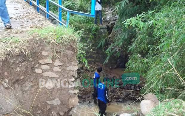 Salah satu sisi jembatan yang amblas dan jatuh ke sungai. foto: INTAN/ BANGSAONLINE