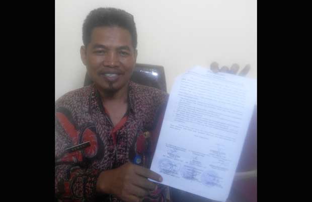 TUNJUKKAN: M Nawari menunjukkan berita acara terkait penertiban stan Pasar Krian Baru, Selasa (14/3). foto: mustain/ BANGSAONLINE.com