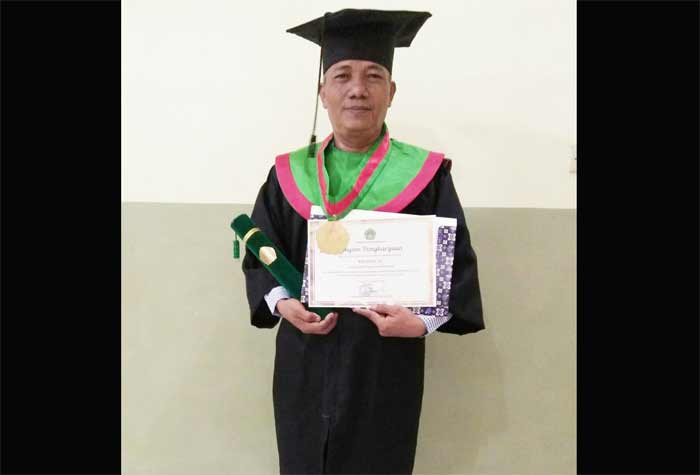 Khamim, S.H., menunjukkan piagam penghargaan lulus S1 Hukum dengan predikat cumlaude.