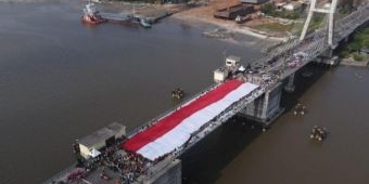 Masyarakat Babel Bentangkan Bendera Merah Putih 78 Meter di Jembatan Emas