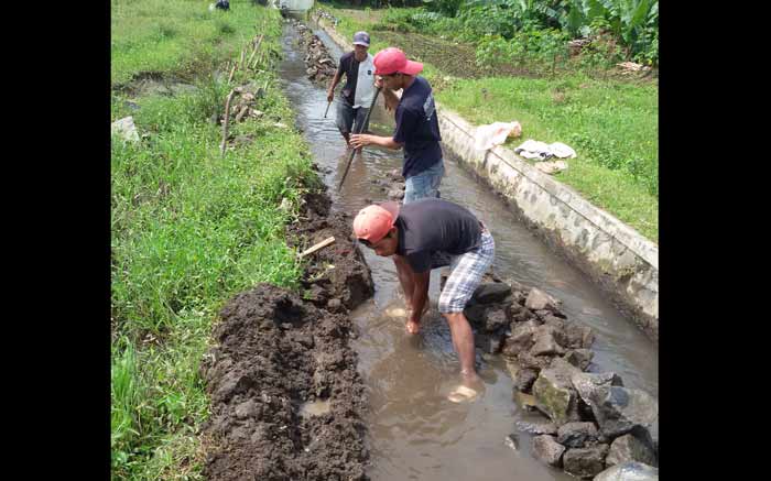 Warga terpaksa memperbaiki sendiri saluran irigasi milik Dinas Pertanian Kabupaten Malang yang rusak parah di desa Pucangsongo Kecamatan Pakis. foto: putut priyono/ BANGSAONLINE