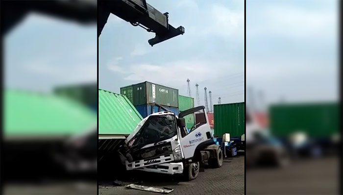 Kontainer saat terlepas dari kendaraan penderek container crane atau Reach Stacker dan menimpa truk di Depo PT BJTI, Perak, Surabaya.