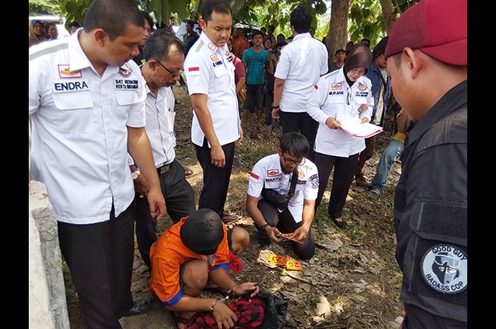 Pelaku saat memperagakan salah satu adegan dalam rekonstruksi yang digelar oleh Polresta Sidoarjo.
