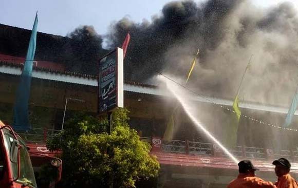 PEKAT - Petugas PMK tengah bekerja keras menjinakkan api yang melalap pertokoan belantai II Sanrio. foto: gunadhi/BANGSAONLINE