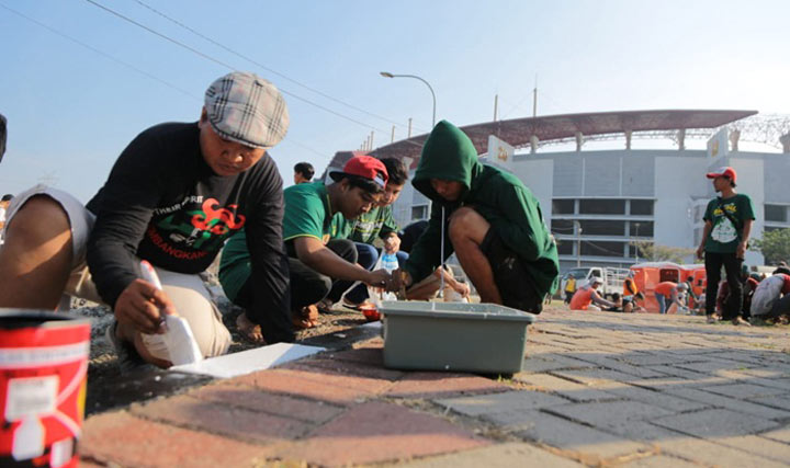 Para Bonek sedang sibuk mengecat paving sekitar GBT.