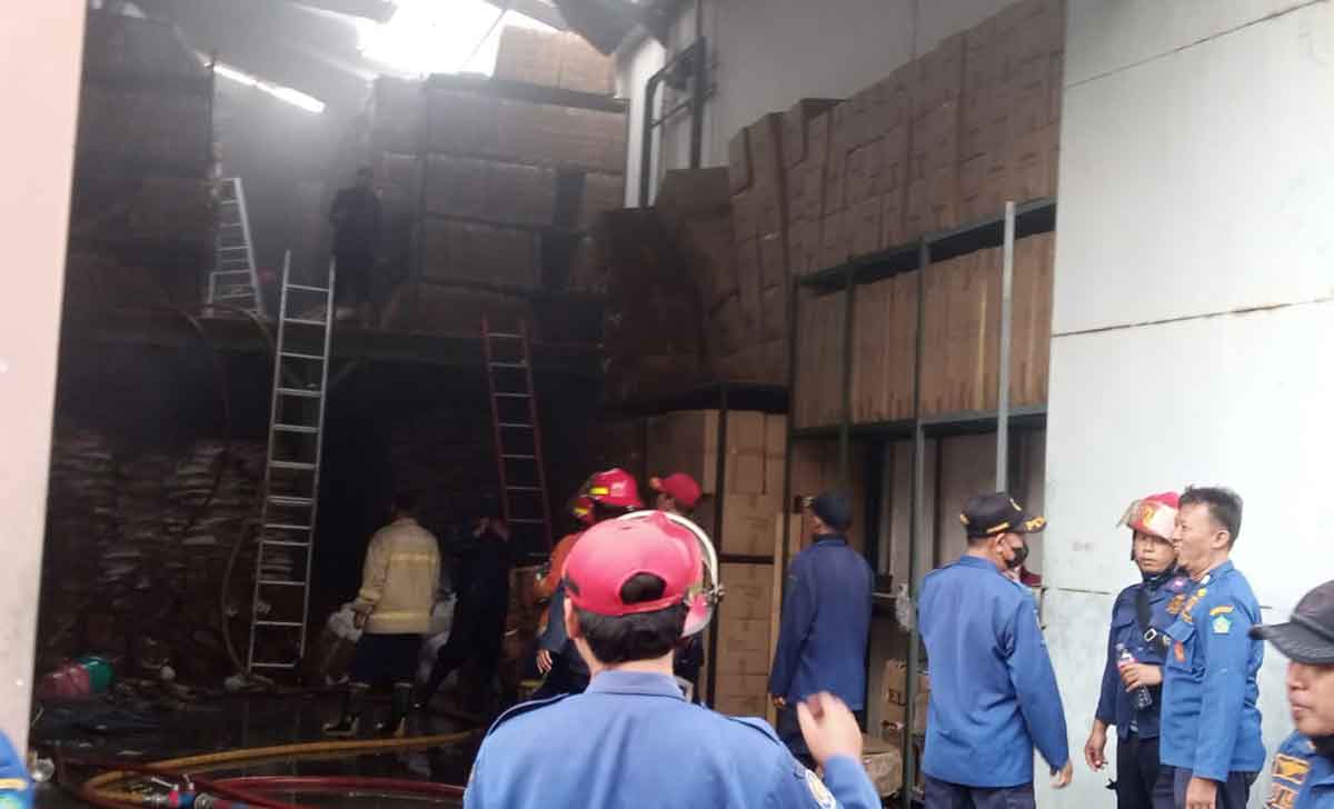 Petugas saat memadamkan api yang membakar gudang kandang kucing di Sidoarjo.
