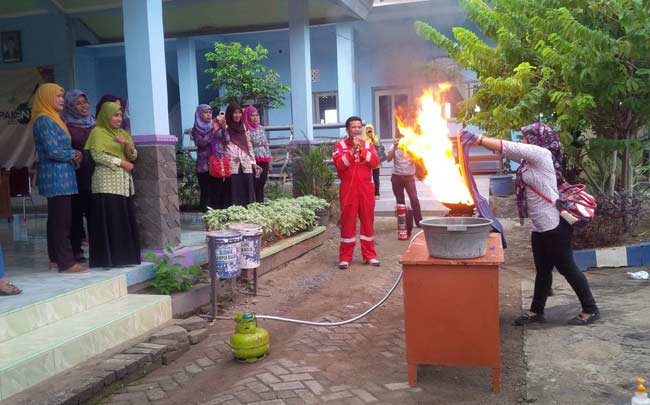 ATRAKSI: Petugas JOB P-PEJ saat mempraktekkan cara memadamkan kobaran api kompor LPG yang benar. foto: eky nurhadi/ BANGSAONLINE.com