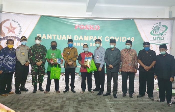 BANTUAN PERDANA: Penyaluran bantuan saat peresmian Posko Bantuan Dampak Covid-19 di kampus Unusida, Senin (6/4). foto: MUSTAIN/BANGSAONLINE
