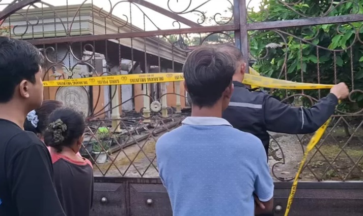 Polisi saat memasang police line di sekitar TKP 