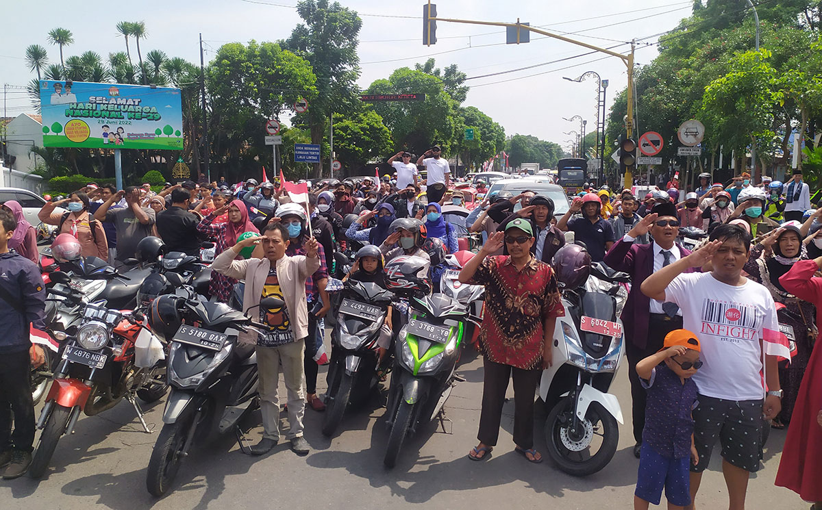 Pengguna jalan saat mengikuti derik-detik proklamasi di depan Pos Polisi Kota Jombang. Foto: AAN AMRULLOH/ BANGSAONLINE