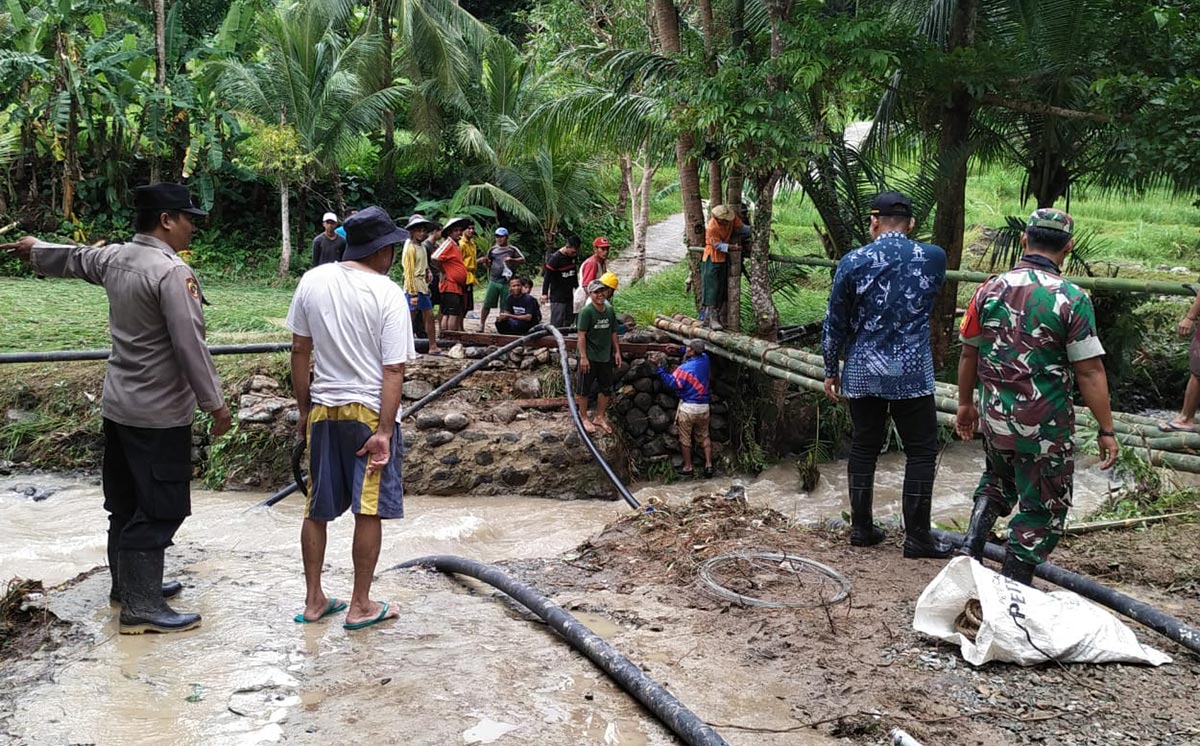 Camat Sangkapura Syamsul Arifin dan pejabat muspika gotong royong dengan warga membuat jembatan darurat. Foto: Ist.