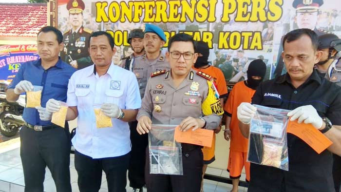 Petugas saat menunjukkan barang bukti hasil penangkapan.